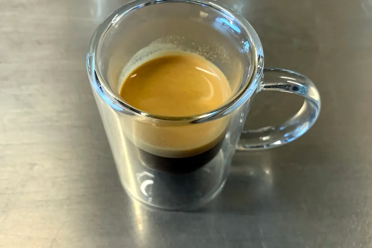 Espresso recién extraído en una taza de cristal de doble pared