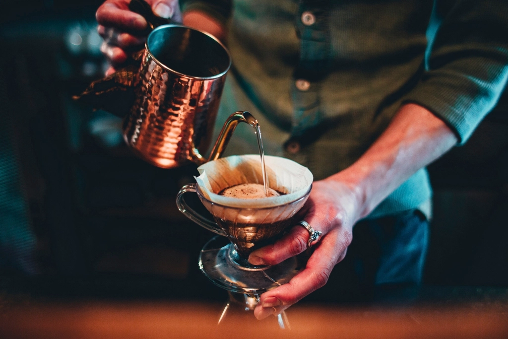 Barista vertiendo agua sobre café de filtro